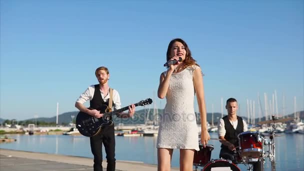 Skupina pouličních hudebníků účinkování na galavečeru v blízkosti moře ve dne - Záběry, video