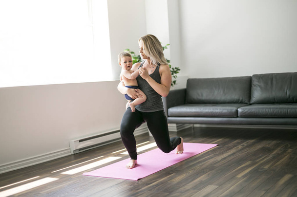 young mother does physical yoga exercises together with her baby - Zdjęcie, obraz