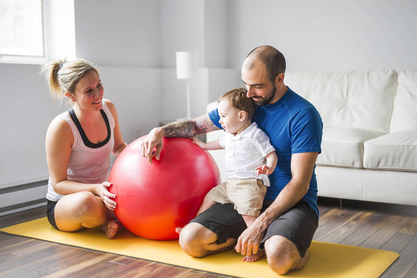 sports family is engaged in fitness and yoga with a baby at home - Foto, Imagem