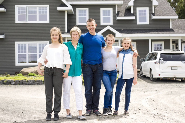 щаслива сім'я, що стоїть перед будинком
 - Фото, зображення