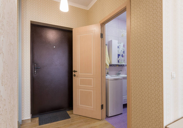 Передпокій, інтер'єр, вхідні двері та відкриті двері у ванну кімнату
 - Фото, зображення