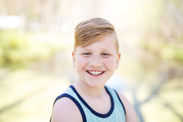 Young redheaded boy playing outside - 写真・画像