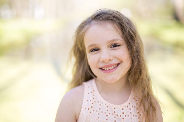 Portrait of a little girl on a yellow background. Girl seven years. - Photo, image