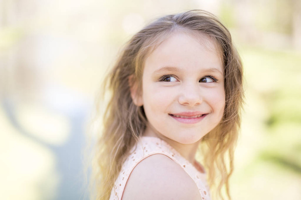 Portrait of a little girl on a yellow background. Girl seven years. - Foto, afbeelding