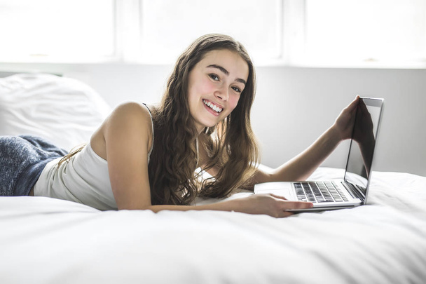 Teenage Girl Lying On Bed Using A Laptop - Фото, изображение