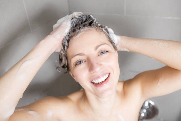Woman in shower washing hair with shampoo - Фото, зображення