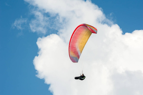 Gleitschirm fliegt in den blauen Himmel vor dem Hintergrund der Wolken. - Foto, Bild