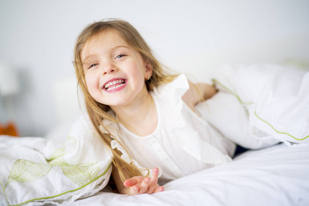 entzückendes kleines Mädchen wachte in ihrem Bett auf - Foto, Bild