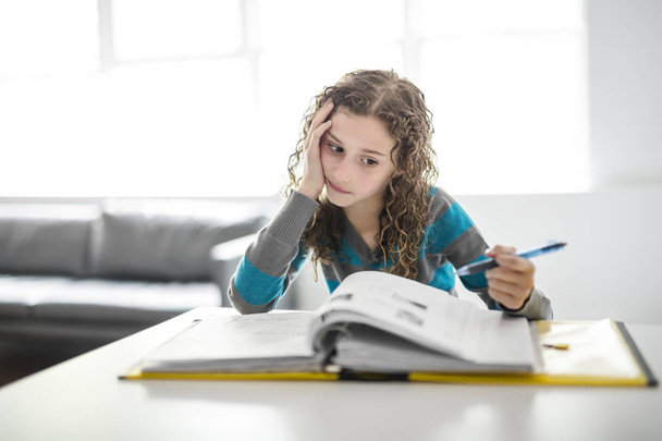 girl of 9 years in a school uniform homework - Photo, Image