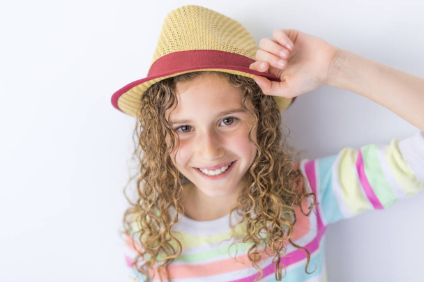 Portrait of 9 years old girl with curly hair, isolated on gray - Foto, Imagem