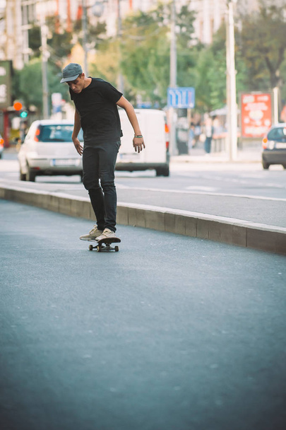 Professional skater riding skate on streets through cars and tra - Valokuva, kuva