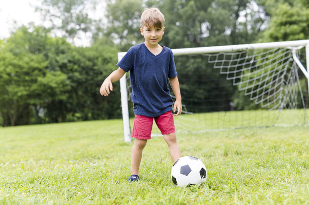Young Boy with football on a field having fun - Foto, imagen