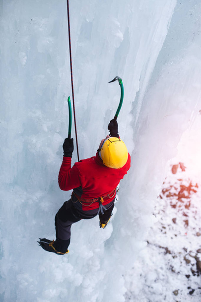 Ο ορειβάτης ανεβαίνει στον πάγο. - Φωτογραφία, εικόνα