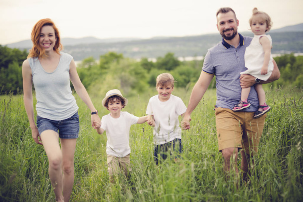 onnellinen perhe niityllä
 - Valokuva, kuva