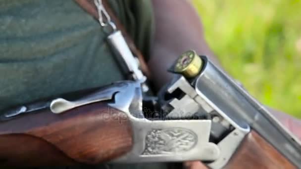 Χέρι χρεώνει κασέτες σε ένα πυροβόλο όπλο - Πλάνα, βίντεο