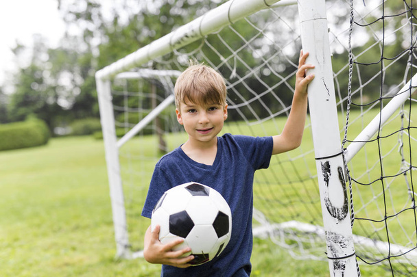 Young Boy with football on a field having fun - Photo, image