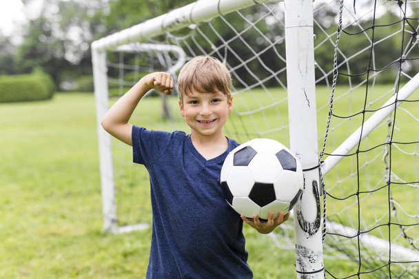 Young Boy with football on a field having fun - Fotó, kép