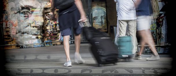 Több utazók gyorsan mozgó station, fogalmi kép bőröndök - Fotó, kép