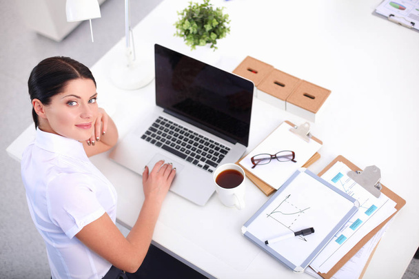Attractive businesswoman sitting on desk in the office - Foto, Imagen