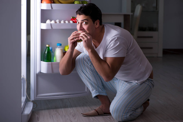 Hombre en el refrigerador comiendo por la noche - Foto, imagen