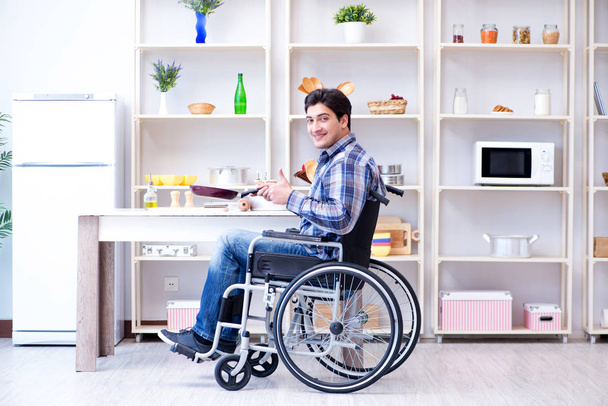 Disabled young man husband working in kitchen - Foto, Bild