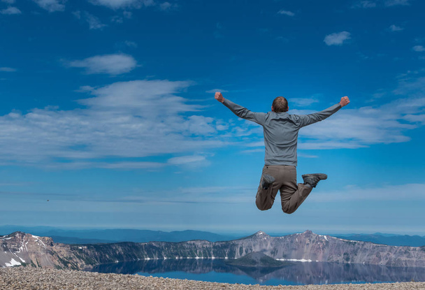 Muž skočí na výhled na Kráterové jezero - Fotografie, Obrázek