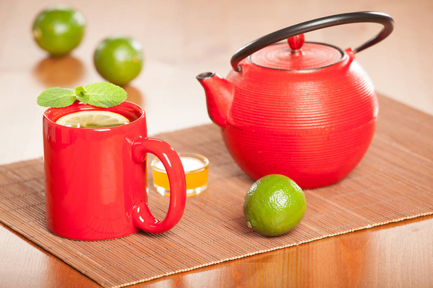 Teapot and cup of tea with lime and mint - Fotoğraf, Görsel