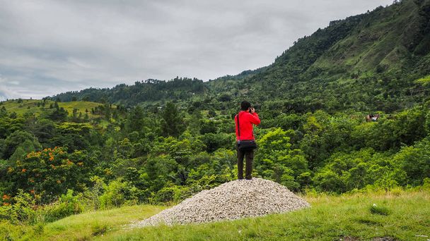 man standing on hill looking at the lake toba - Photo, Image