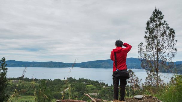 ο άνθρωπος που στέκεται πάνω σε λόφο που βλέπουν τη λίμνη toba - Φωτογραφία, εικόνα