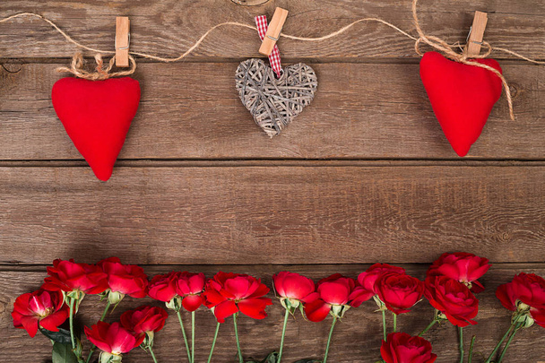 Marco con rosas y corazones rojos sobre fondo de madera. Día de San Valentín
 - Foto, imagen