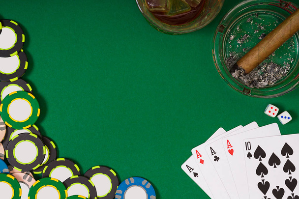 concepto de juego, fortuna y entretenimiento: primer plano de fichas de casino, vaso de whisky, cartas y cigarros en la superficie de la mesa verde
 - Foto, Imagen