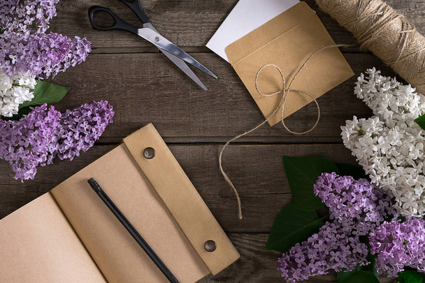 Flor de lila sobre fondo rústico de madera con cuaderno para mensaje de saludo. Vista superior
 - Foto, Imagen