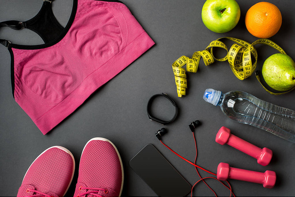 Atleti con abbigliamento femminile, scarpe da ginnastica e bottiglia d'acqua su sfondo grigio
 - Foto, immagini