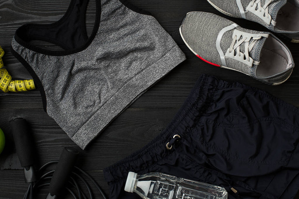 Athlètes avec vêtements féminins, baskets et bouteille d'eau sur fond sombre
 - Photo, image