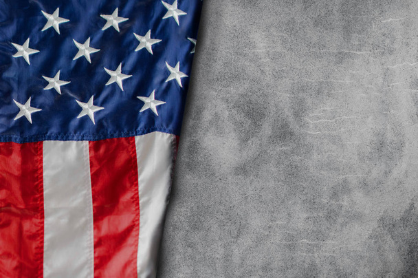 Bandeira americana deitada livremente no fundo de cimento em branco
 - Foto, Imagem