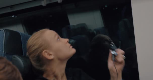 Woman commuter charging cellphone in train - Filmati, video