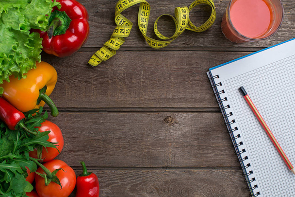 Desporto e dieta. Legumes e centímetro. Pimentos, tomates, salada em fundo rústico
 - Foto, Imagem