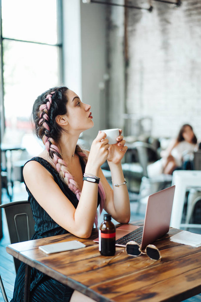 Young woman sitting in coffee shop - Fotografie, Obrázek