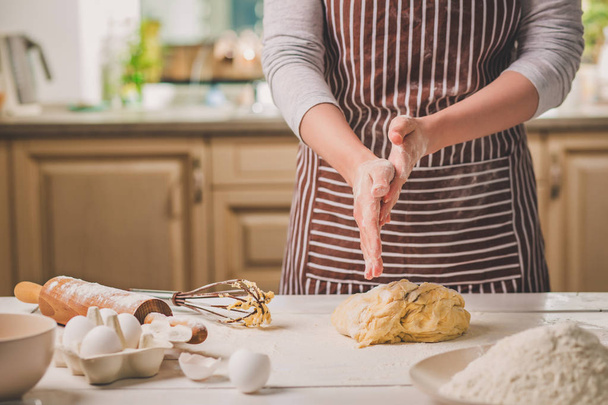 La mujer abofetea sus manos sobre el primer plano de la masa. Baker terminando su panadería, agitar la harina de sus manos, espacio libre para el texto
. - Foto, imagen