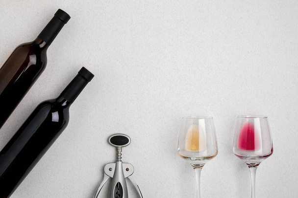 Bicchieri e bottiglie di vino rosso e bianco su sfondo bianco vista dall'alto
 - Foto, immagini