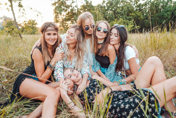 Six filles dans la nature sont assises sur l'herbe. - Photo, image