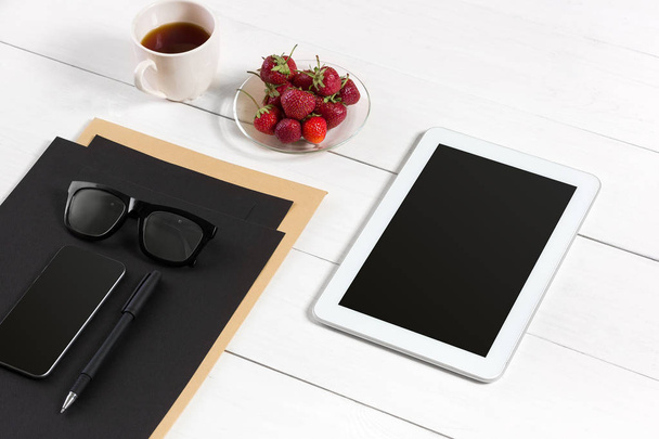 Σύγχρονο χώρο εργασίας με υπολογιστή ψηφιακό tablet και κινητό τηλέφωνο, φλιτζάνι καφέ, στυλό και κενό φύλλο χαρτιού. - Φωτογραφία, εικόνα