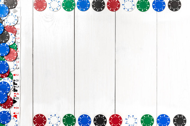 Játékkártyák és póker zseton, fehér fa háttér. Szemközti nézet - Fotó, kép