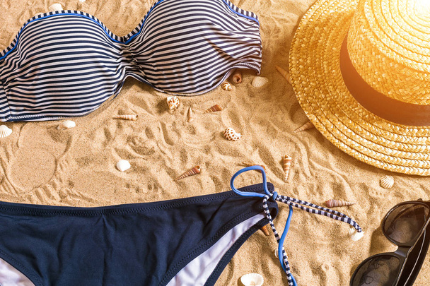Zomer bikini en badkamerstoebehoren stijlvolle strand, strand bikini zomer outfit en zee zand als achtergrond, bovenaanzicht, Concept - Foto, afbeelding