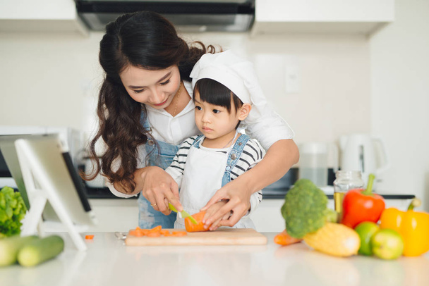 Mère et fille cuisine des légumes
 - Photo, image