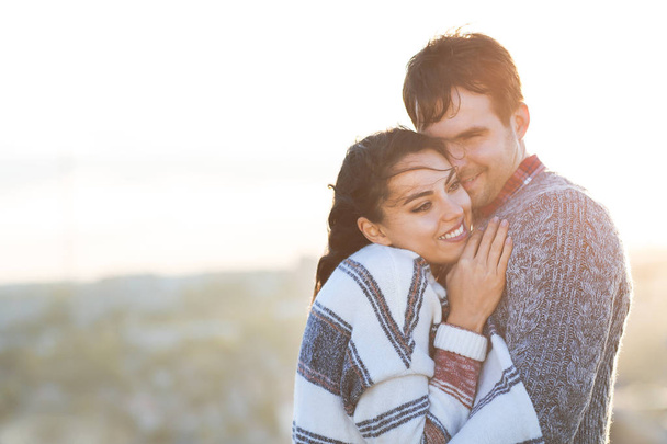 Joven hombre y mujer abrazar y divertirse al aire libre - Foto, imagen