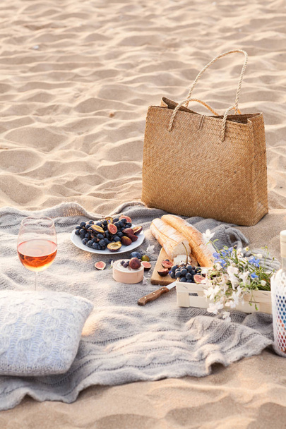 A beautiful picnic with fruit and wine at sunset near the sea - Foto, Imagem