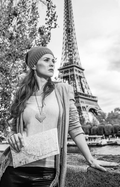 young tourist woman on embankment in Paris, France with map looking into the distance - Zdjęcie, obraz