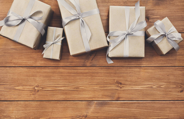 Подарки в подарочных коробках на деревянном фоне
 - Фото, изображение