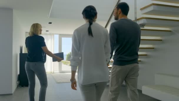 Profesionální realitní makléř vítá krásná mladá dvojice do prostorných a moderních domů. S podlahou francouzskými okny a výhledem na moře. - Záběry, video